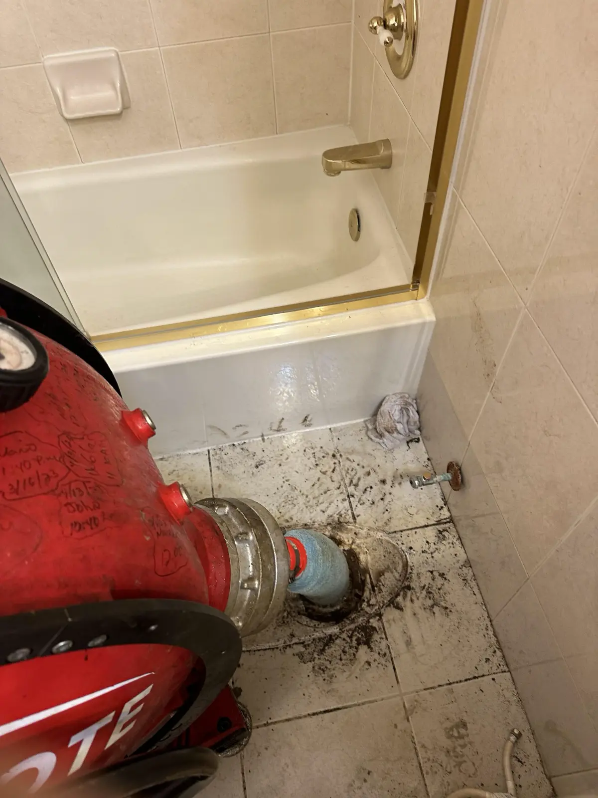 USA Plumbing technician hydro-jetting a clogged residential bathtub drain